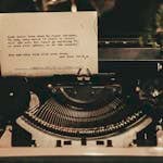 An antique typewriter displaying a typed poem in a nostalgic sepia tone.